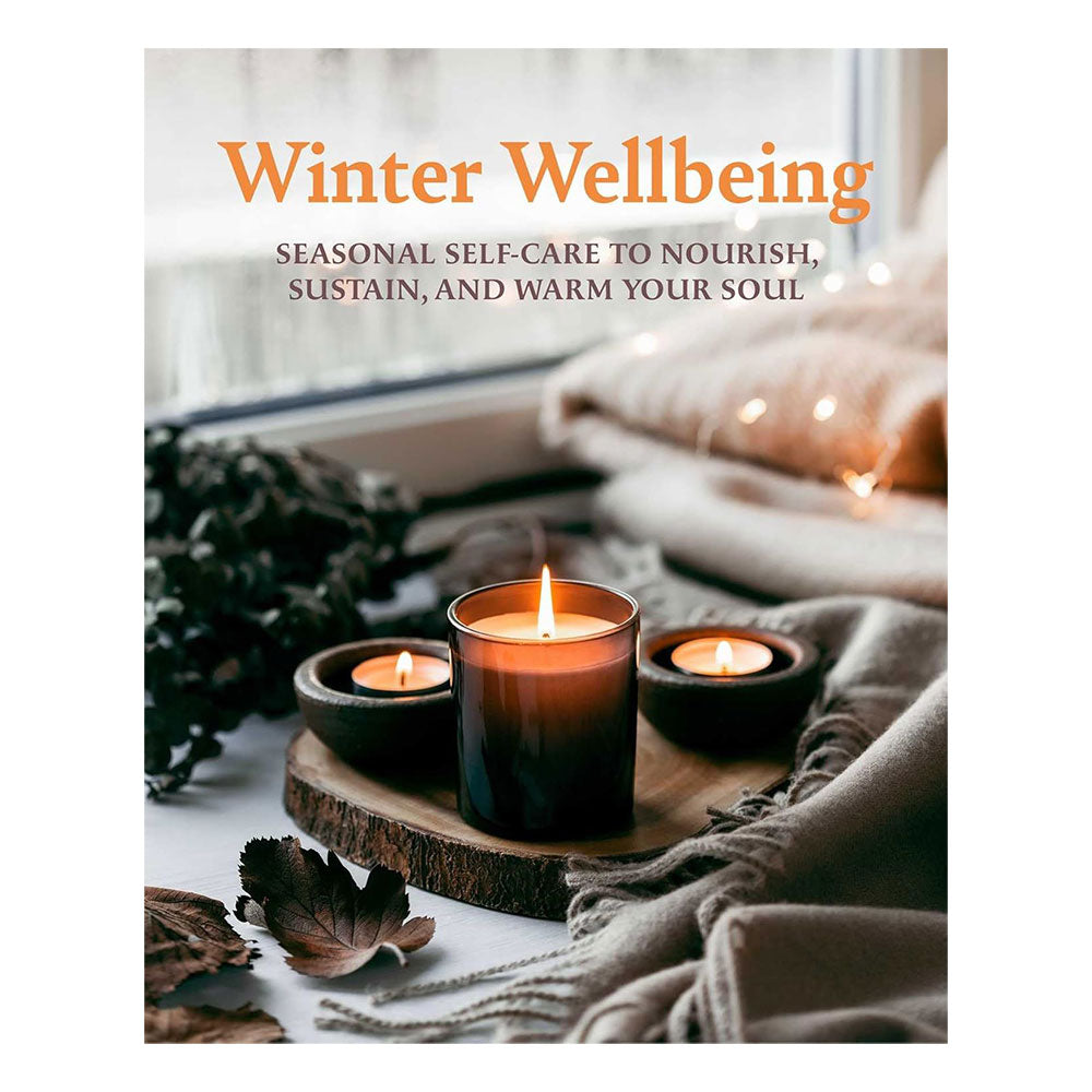 Book titled 'Winter Wellbeing' with candles and cosy decor on a white background