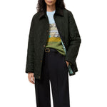 A model wearing a dark green quilted jacket with a dark brown collar, layered over a colourful graphic sweater of Birkhall and black trousers, against a plain white background.