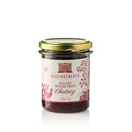 A glass jar of Highgrove Organic Spiced Fruit Chutney with a gold metal lid and a cream-colored label decorated with pink illustrations, set against a plain white background.