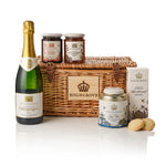 Highgrove branded products including champagne, tea, and shortbread, arranged around a wicker hamper on a white background