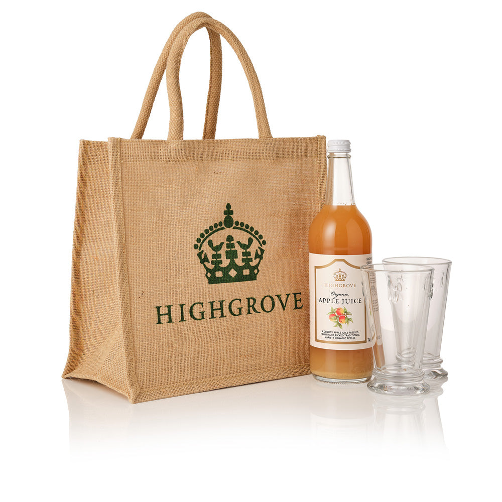 Jute bag with Highbrove branding, a bottle of apple juice, and two glasses on a white background