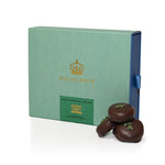 Green Highgrove box with dark peppermint creams on a white background