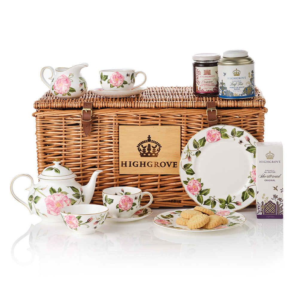 The King's Rose floral design tea set with shortbread biscuits, loose tea tea and strawberry preserve on a Highgrove wicker hamper.