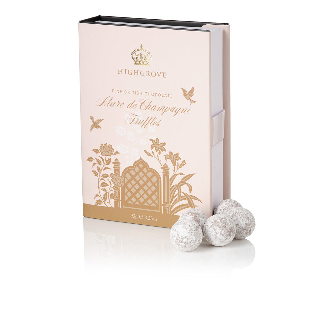 Highgrove Fine British Chocolate 'Mare de Champagne' Truffles in a pale pink and gold box, with three coated truffles displayed in front on a white background.