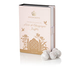 Highgrove Fine British Chocolate 'Mare de Champagne' Truffles in a pale pink and gold box, with three coated truffles displayed in front on a white background.