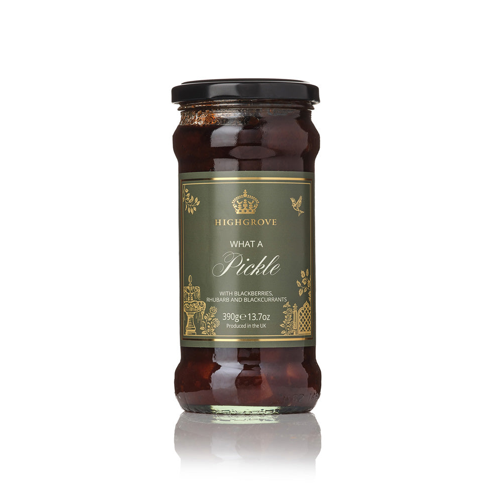 A glass jar of Highgrove What a Pickle: blackberries, rhubarb and blackcurrants, featuring a dark olive green label with gold lettering and a black lid, set against a clean white background with a soft reflection.