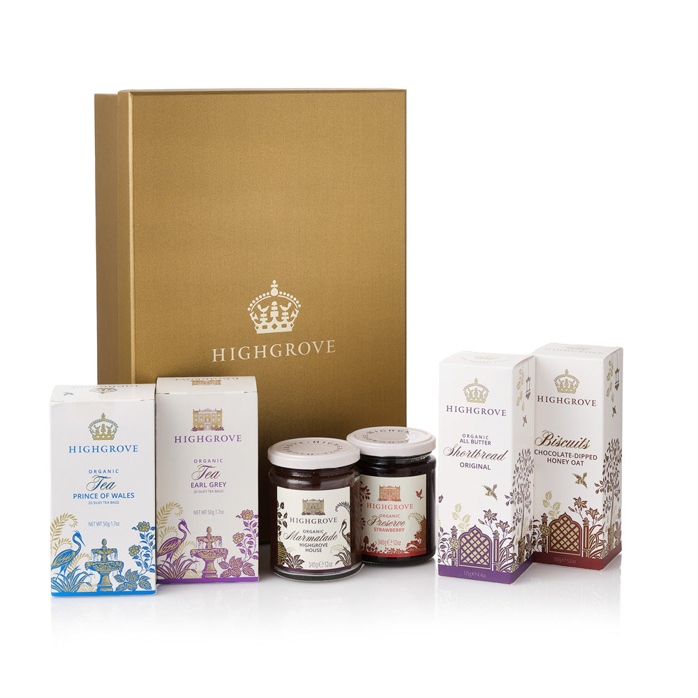 Highgrove gift set featuring a large gold box, a box of organic tea, a box of biscuits, two jars of preserves, and two boxes of honey, arranged on a white background.