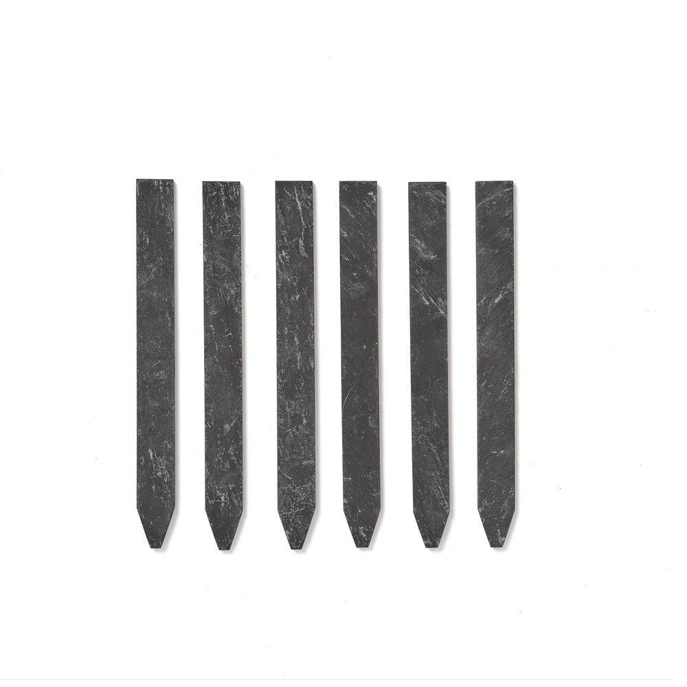 Six dark grey slate seed markers with pointed tips, arranged in a row on a plain white background.