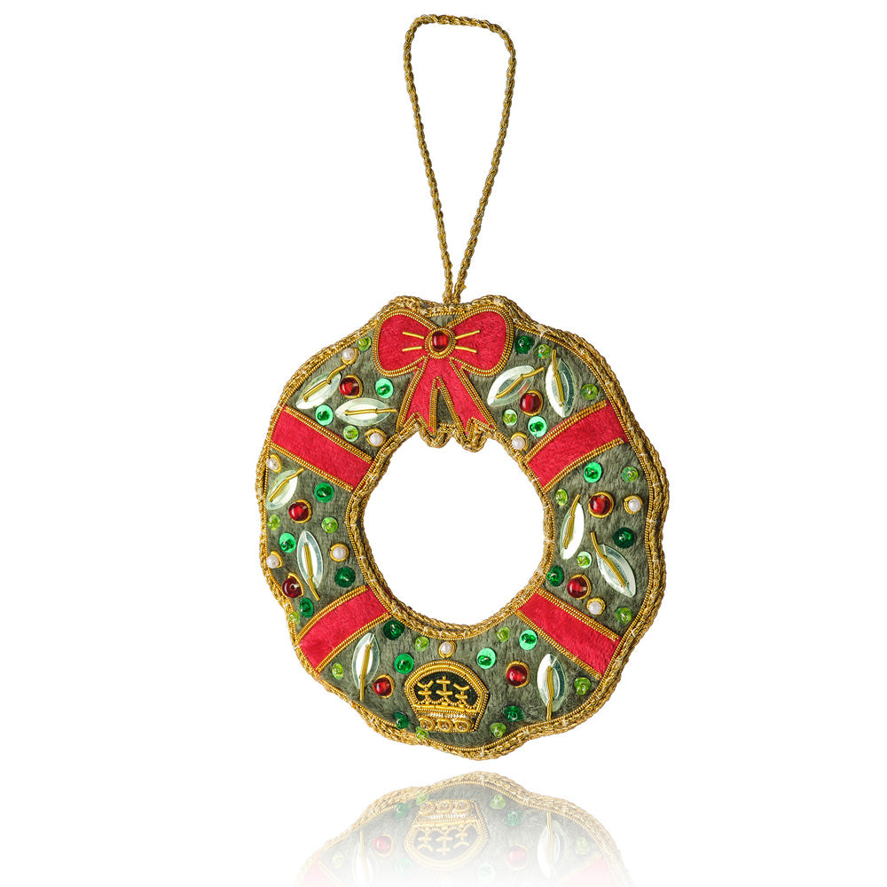 Decorative wreath ornament with red ribbon and gold accents on a white background