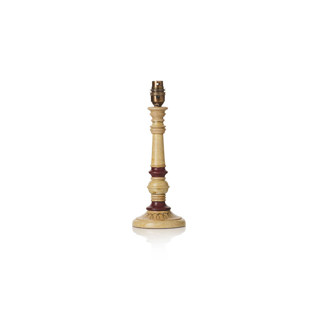 A vintage-style table candlestick or lamp post with a light beige wood body, dark reddish-brown turned accents, and a brass-colored metal socket at the top, shown on a white background with a soft reflection.