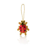 Red and gold ladybug ornament on a white background