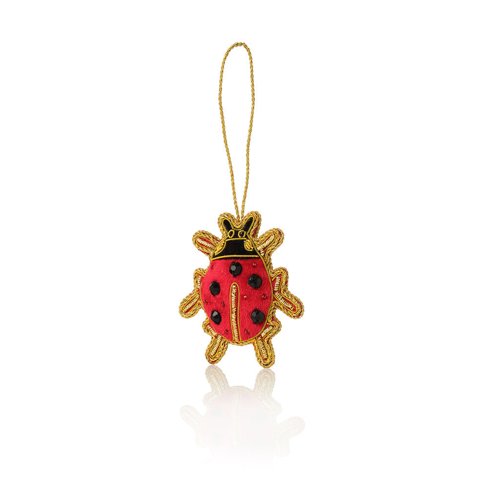 Red and gold ladybug ornament on a white background