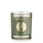 Green candle in a glass holder with a gold emblem on a white background