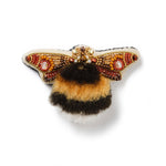 Decorative bee brooch with embroidered wings and fluffy body on a white background