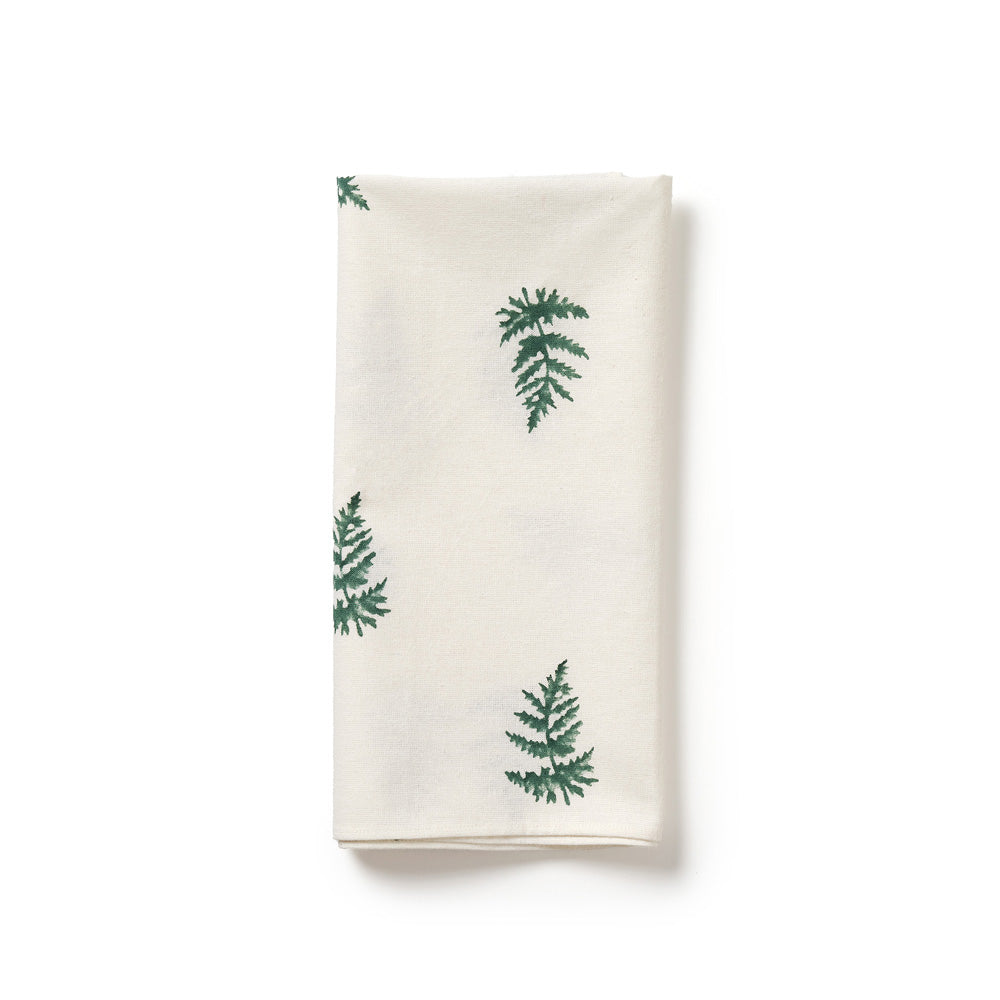 White napkin with green fern patterns on a white background