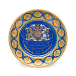 Decorative plate with royal crest and text on a white background