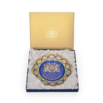 Decorative plate with a blue and gold design in a matching box on a white background
