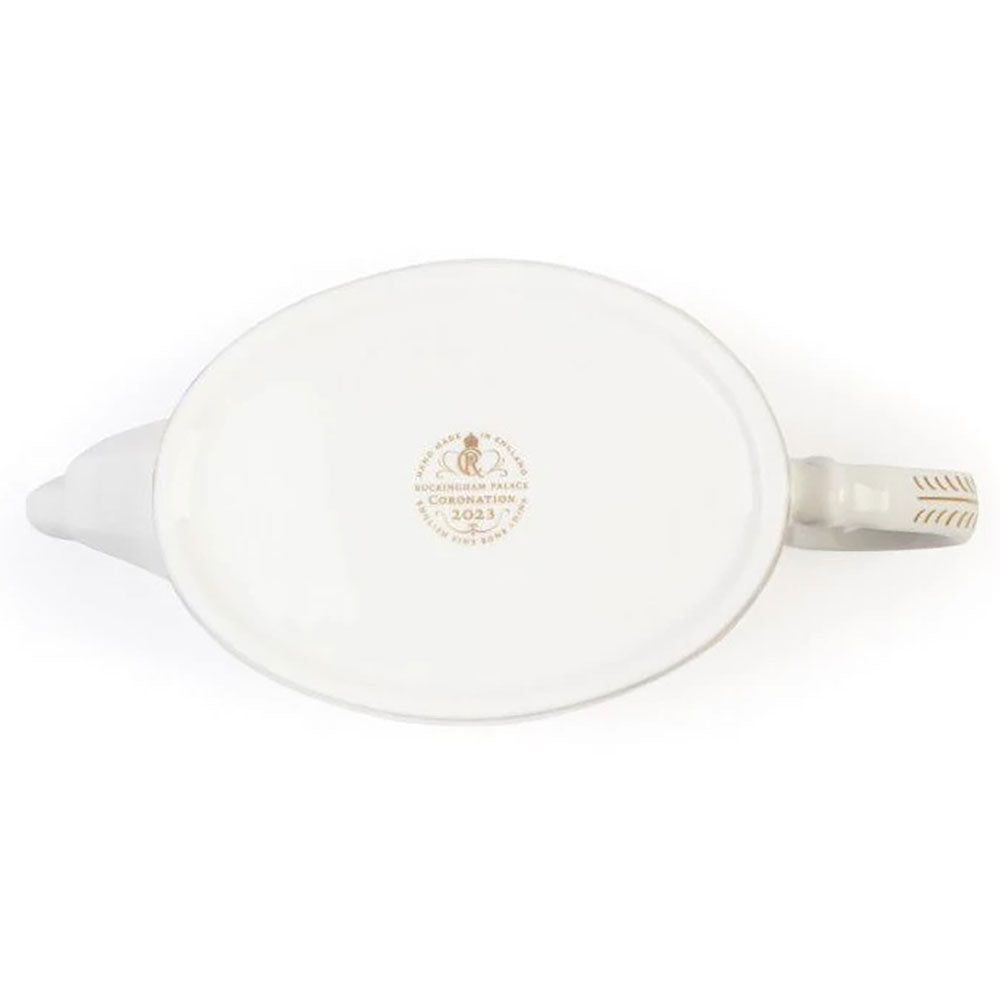 White ceramic teapot with coronation emblem on a white background