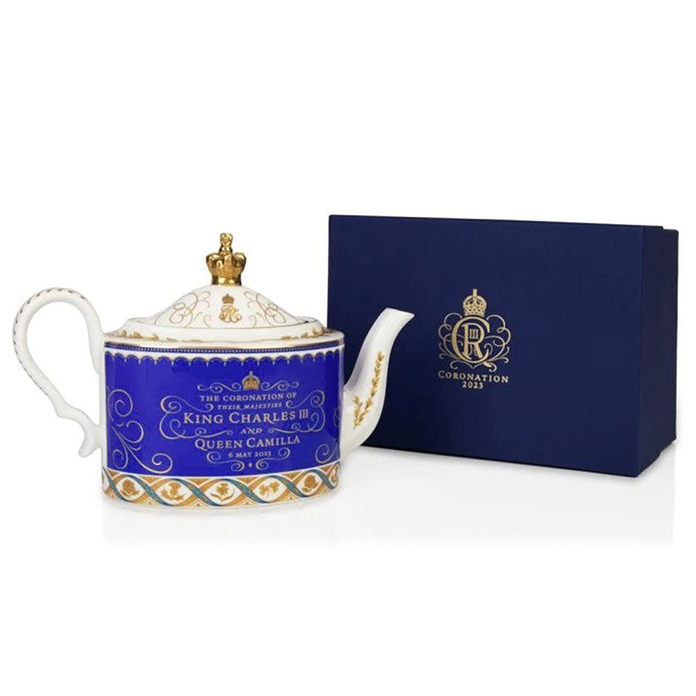 Teapot with a blue lid featuring a coronation design and 'Coronation 2023' text, next to a matching box on a white background.