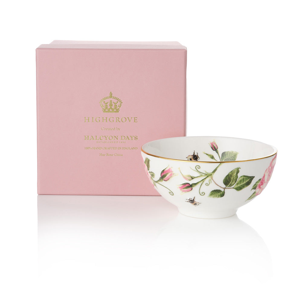 White ceramic bowl with The King's Rose floral design next to a pink box with gold 'Highgrove' branding on a white background