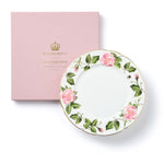 Decorative plate with The King's Rose floral design and gold 'Highgrove' branding on a pink box.