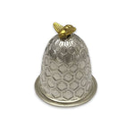 A silver bell-shaped thimble with a honeycomb pattern, featuring a small gold bee ornament on top and a circular gold ring at the base, set against a plain white background.