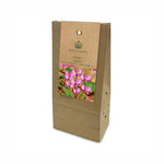 A brown kraft paper grow bag package for Highgrove Cyclamen coum, featuring a hanging label with a photo of pink cyclamen flowers and the Highgrove brand logo.