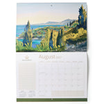 A hanging wall calendar page showing a coastal landscape painting across the top and a monthly calendar grid for August 2027 below. The artwork depicts green cliffs of Corfu, blue water, and distant mountains under a pale sky.