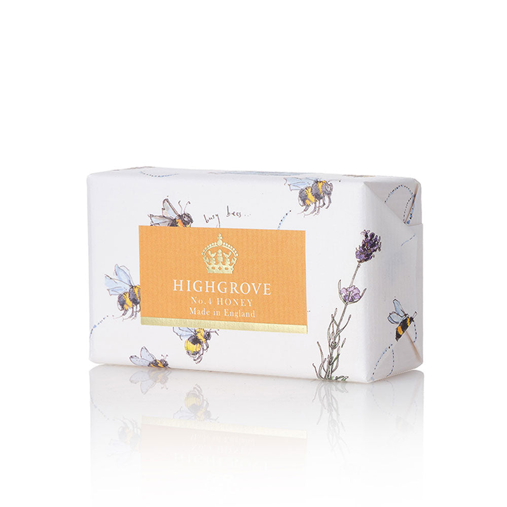 Highgrove No. 4 Honey soap bar wrapped in white paper with illustrations of bees and lavender, featuring a central orange label with a gold crown logo.
