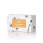 Highgrove No. 4 Honey soap bar wrapped in white paper with illustrations of bees and lavender, featuring a central orange label with a gold crown logo.
