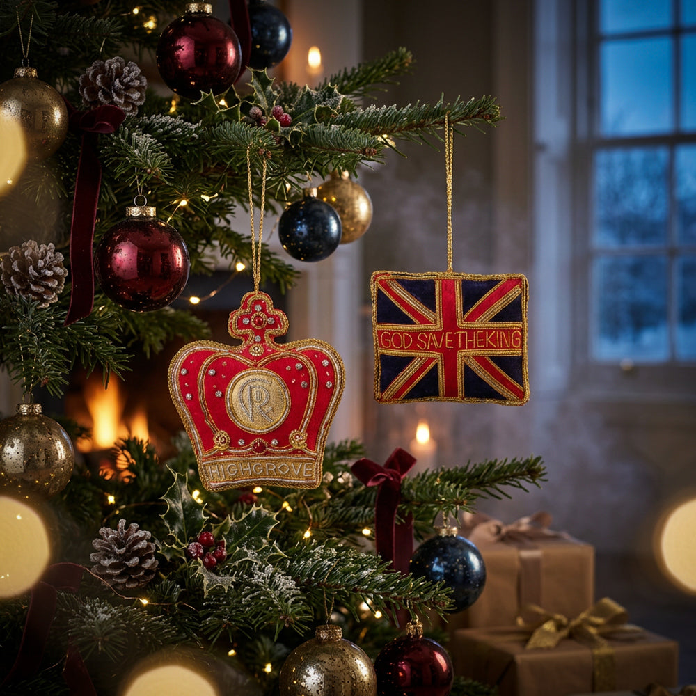 Festive Christmas tree with red, gold and blue ornaments, featuring a crown-shaped “ROYAL GROVE” bauble and a Union Jack “GOD SAVE THE KING” decoration, promoting Highgrove Christmas Lunch.